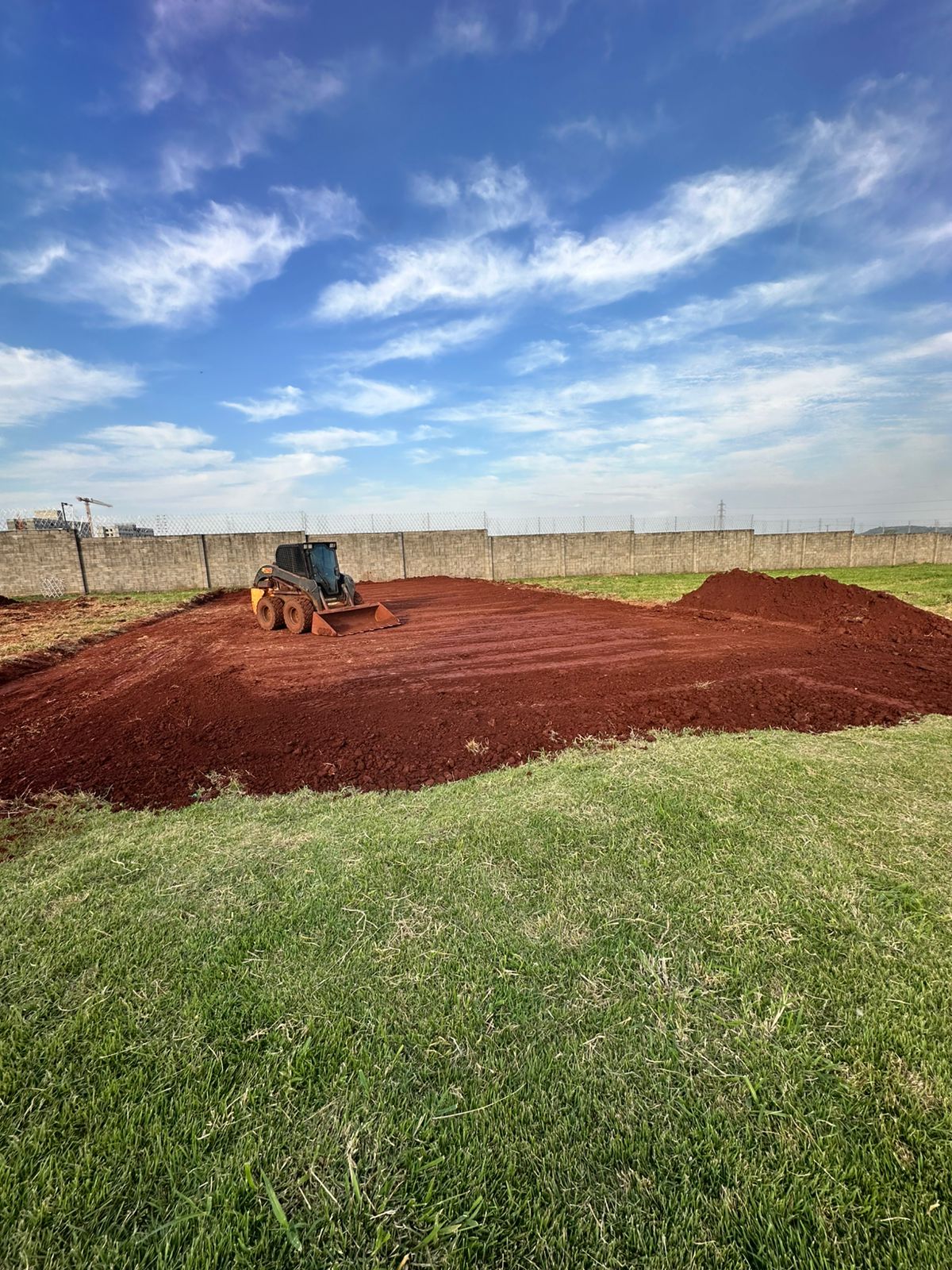 Area nivelada com maquina sobre terra vermelha